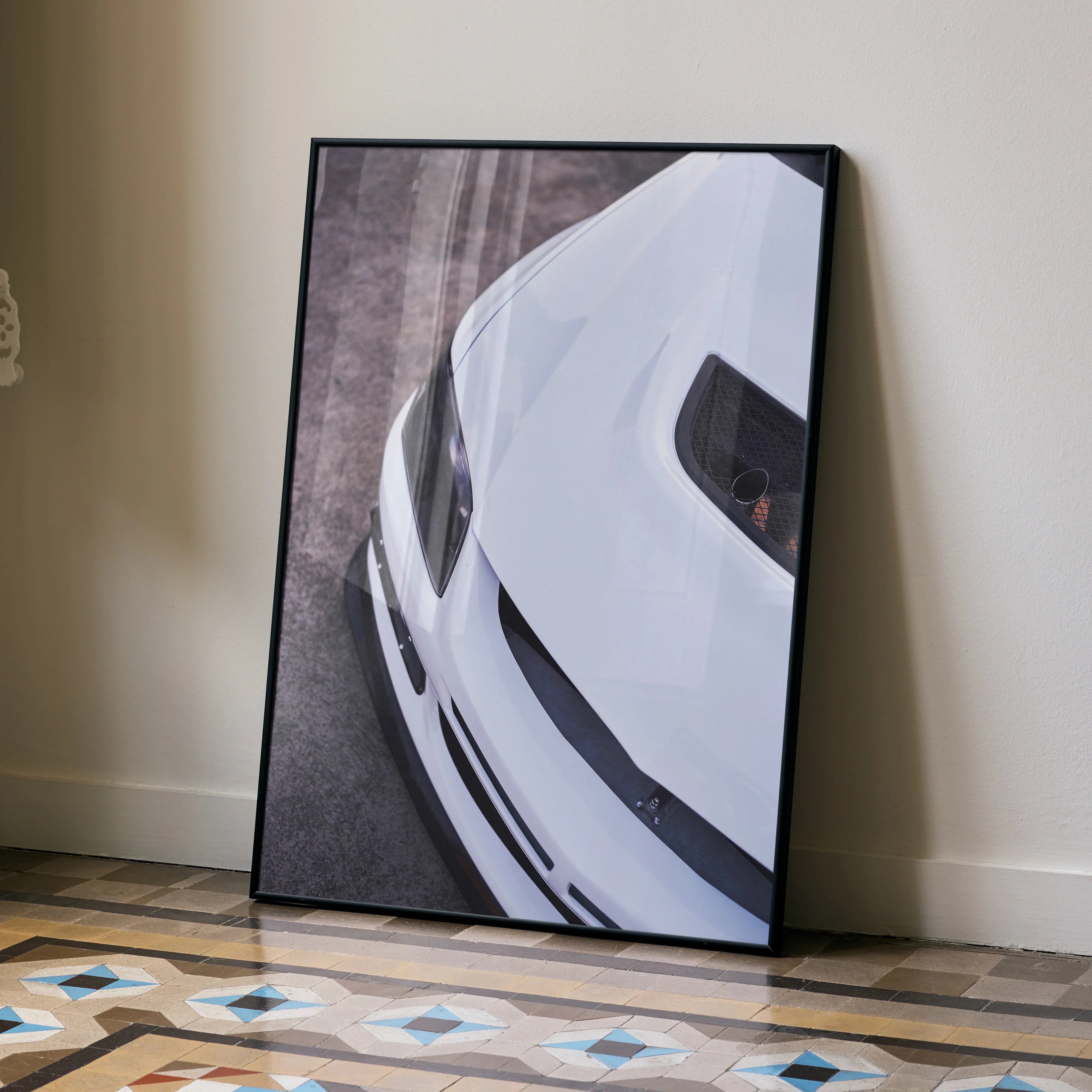 White Mitsubishi Evo 8 close-up poster with black frame leaning against beige wall, automotive wall art.