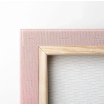 Corner of stretched canvas art with natural wood frame and pink fabric backing, museum-quality wall art canvas.