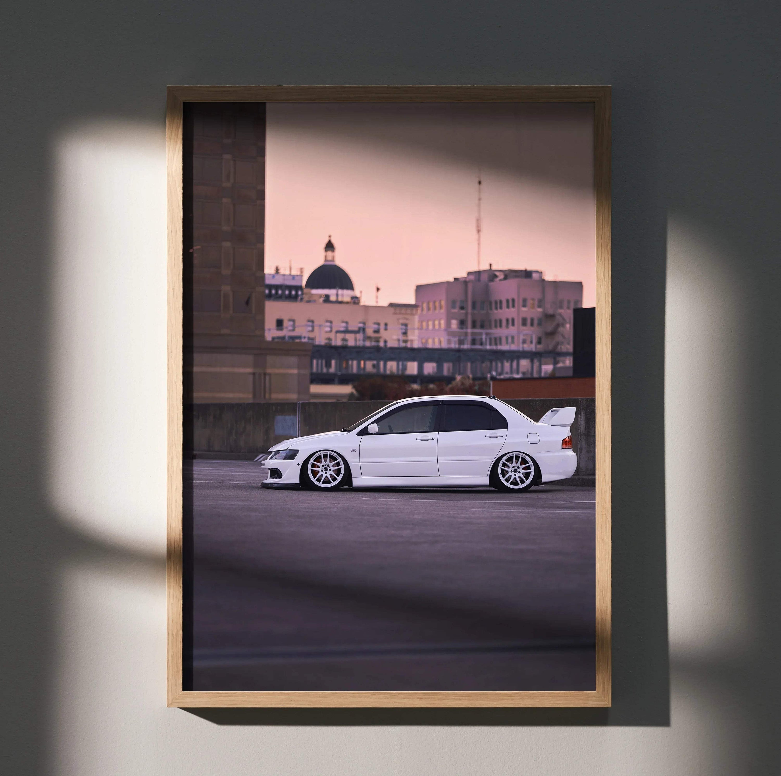 Mitsubishi Evo 8 poster wall art with sleek white car against city skyline at dusk in wooden frame.