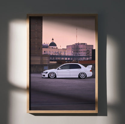 Mitsubishi Evo 8 poster wall art with sleek white car against city skyline at dusk in wooden frame.