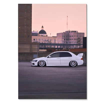 White Mitsubishi Evo 8 parked at dusk with city skyline in pink sky poster wall art.