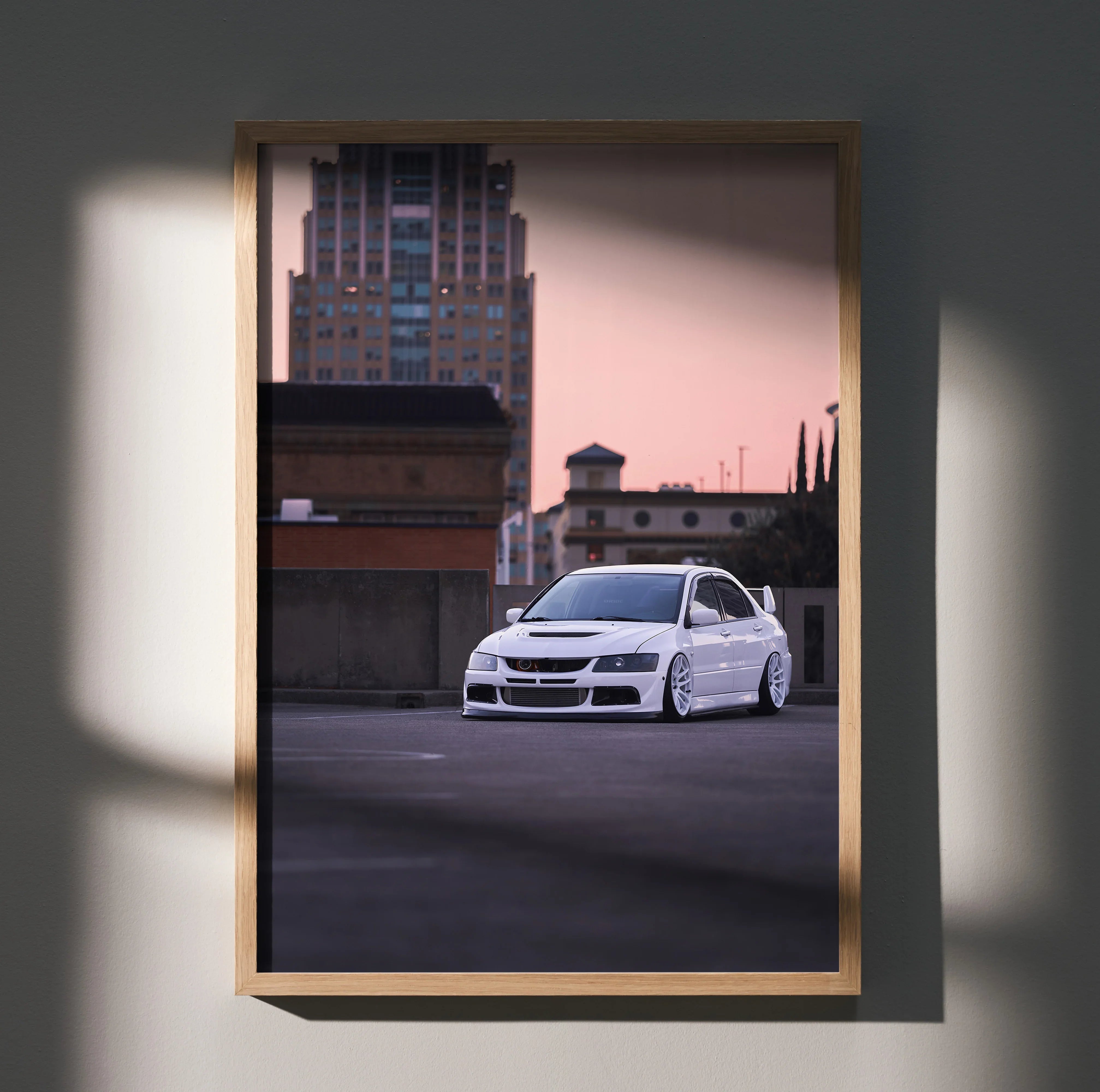 Mitsubishi Evo 8 white sports car poster with urban sunset background wall art in wooden frame.