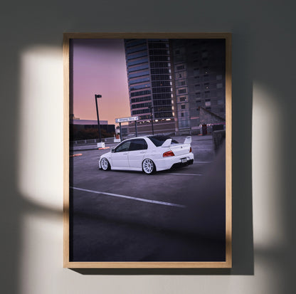 White Mitsubishi Evo 8 parked at sunset with city skyline background poster wall art.