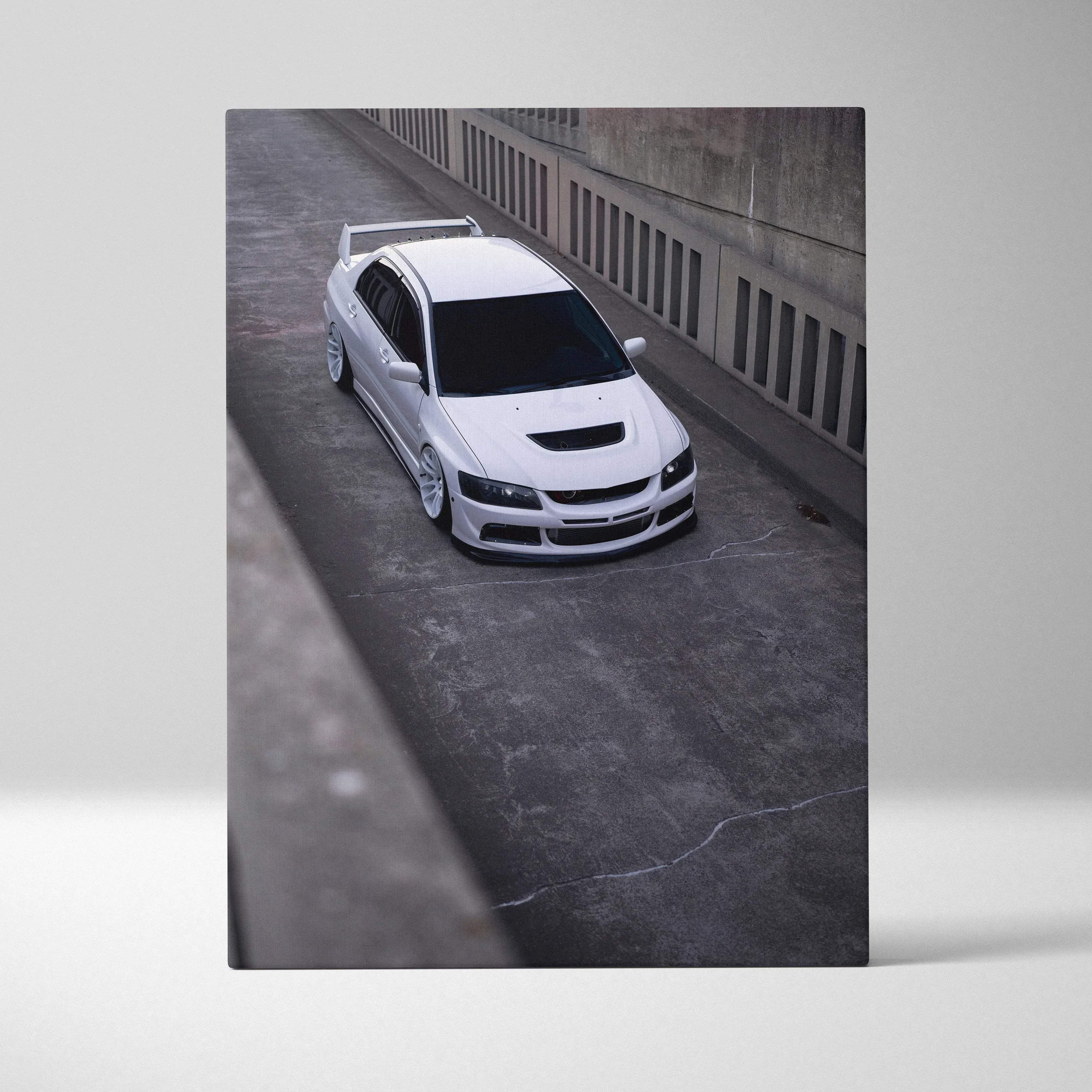Canvas wall art featuring a white mitsubishi lancer evolution with blacked-out windows and rear spoiler on concrete background