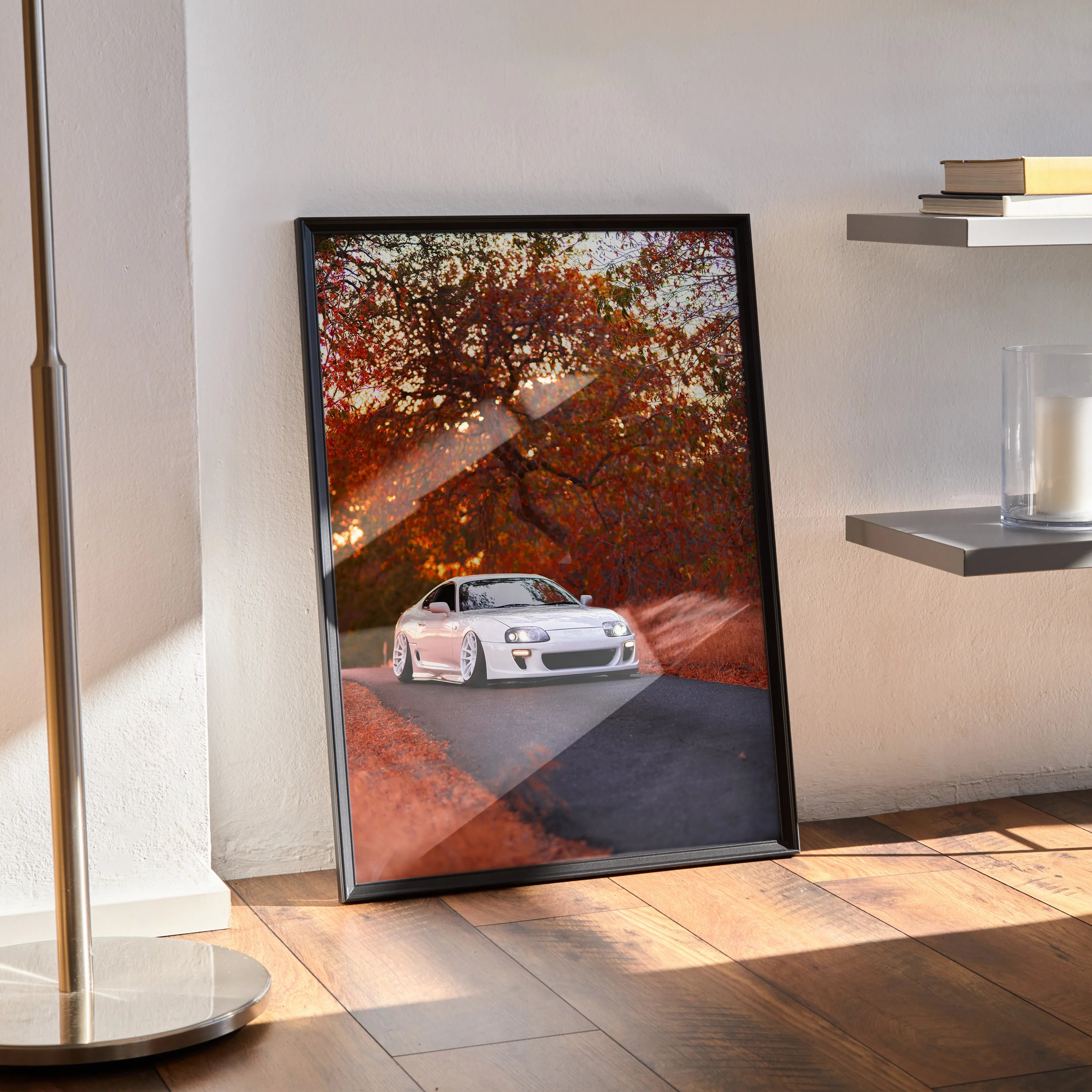 Toyota Supra MK4 poster with autumn background, framed wall art leaning on floor.