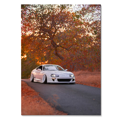Toyota Supra MK4 white sports car on autumn road poster, vibrant wall art with fall colors.