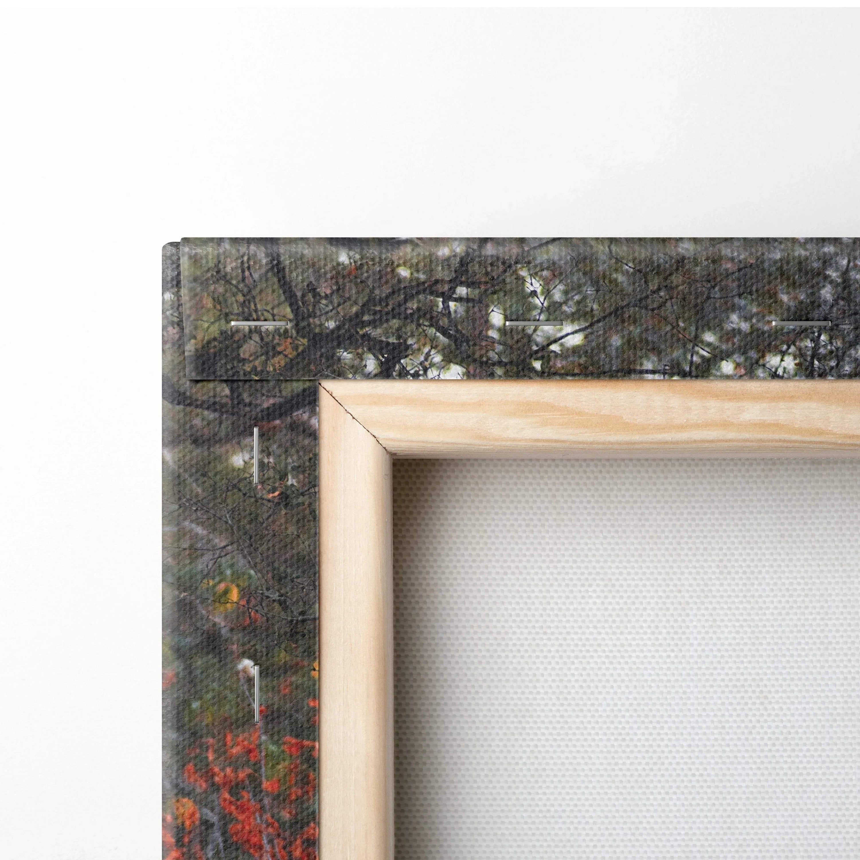 Close-up of wooden-framed canvas art with textured white fabric and dark abstract wall art background.