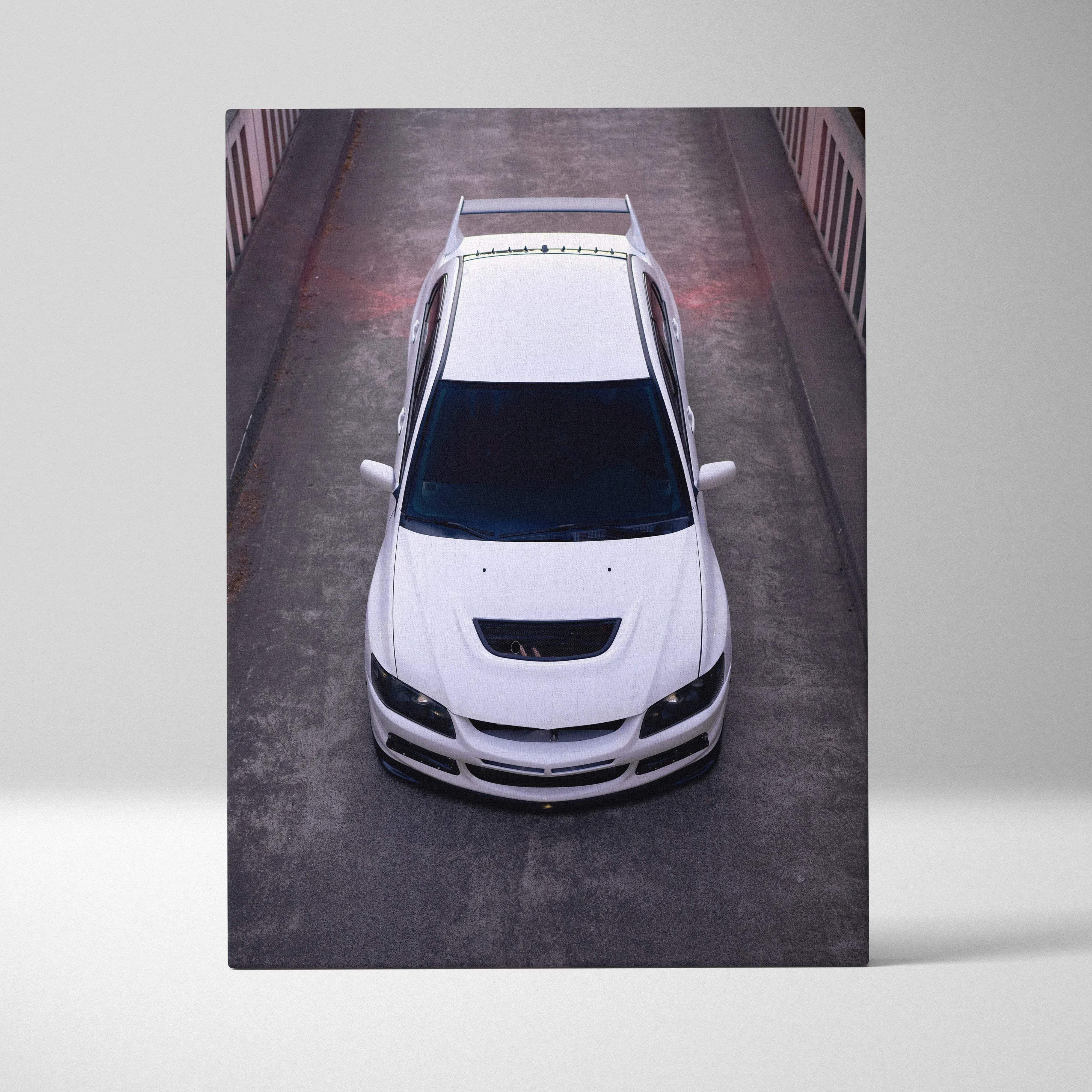 Canvas wall art featuring a white mitsubishi lancer evolution 8 with black accents on concrete background