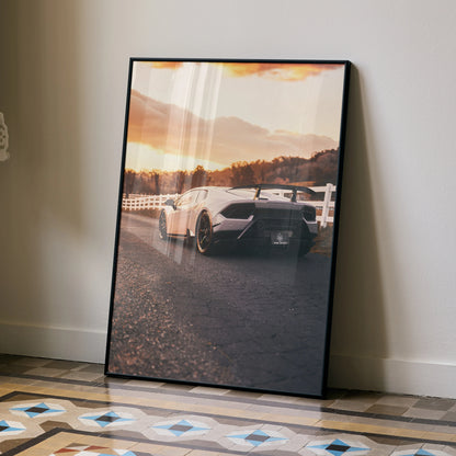 Lamborghini Huracan poster wall art featuring rear view of white sports car at sunset with framed black border.