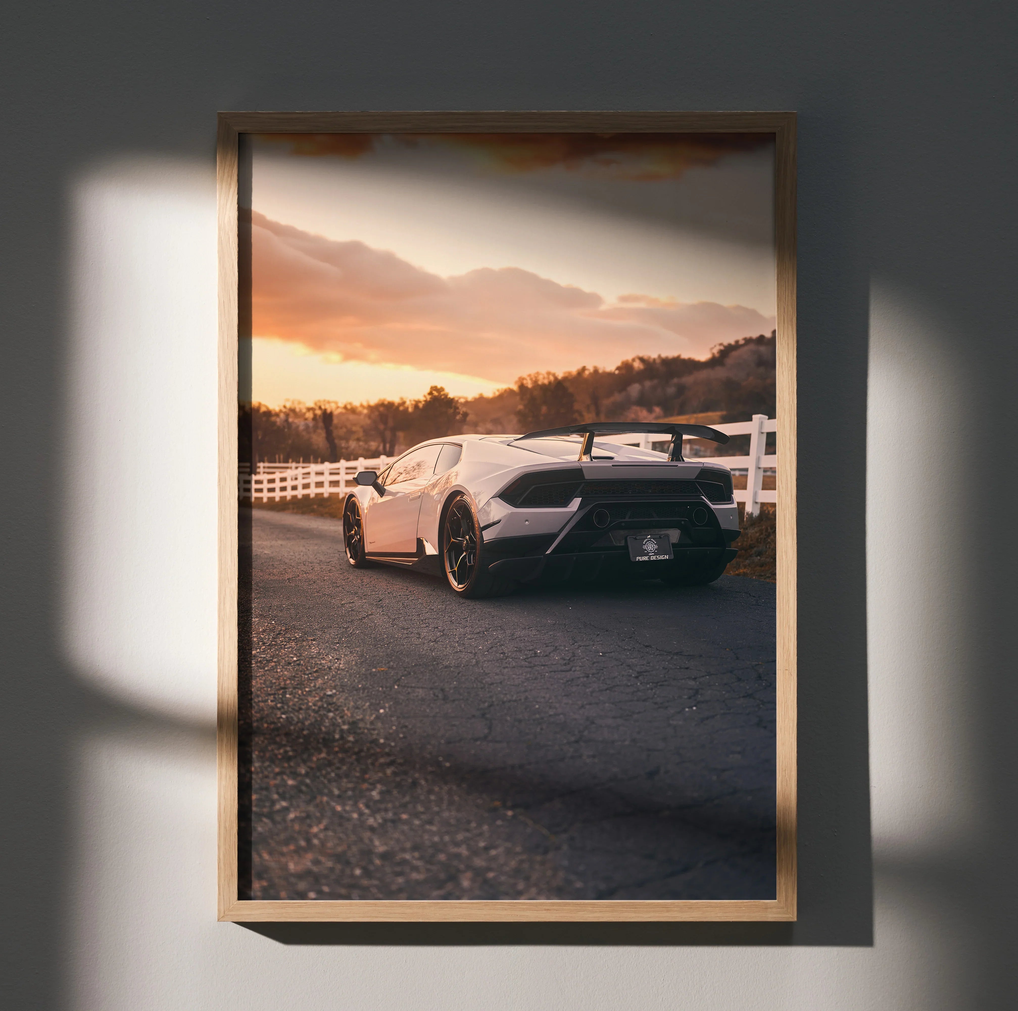 Lamborghini Huracan poster wall art featuring rear view of white sports car at sunset with scenic background.