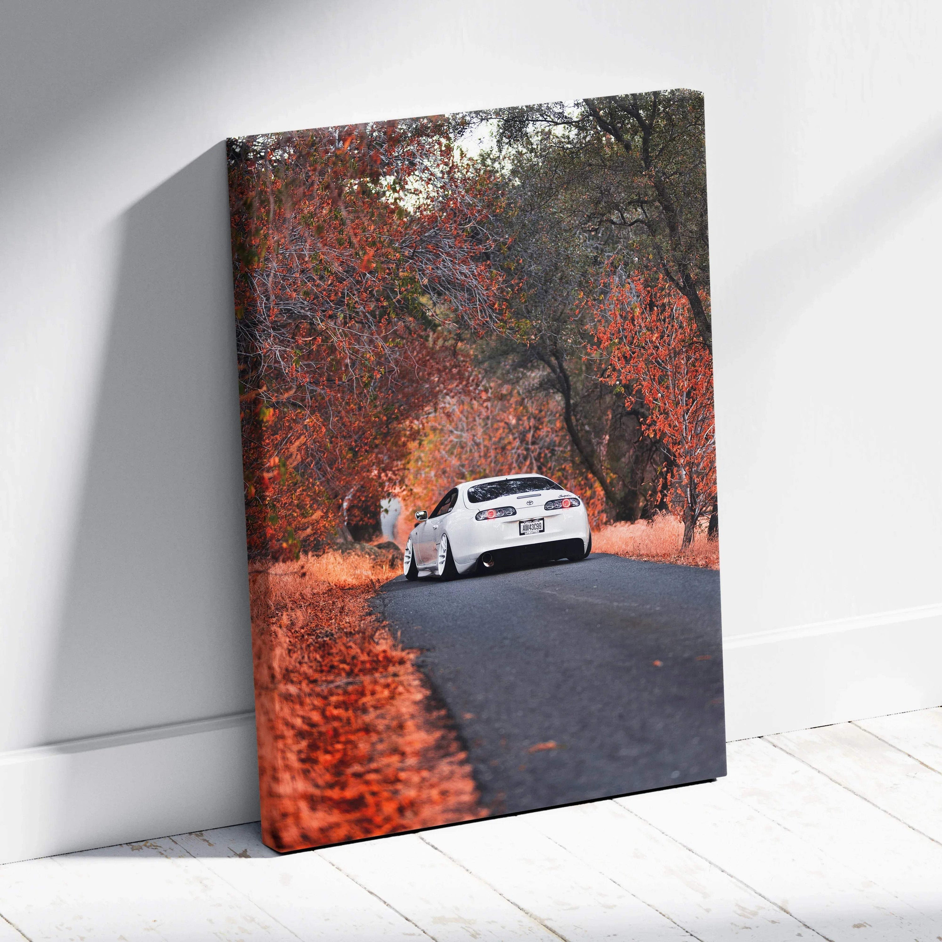 Toyota Supra MK4 driving on road surrounded by autumn trees canvas wall art.