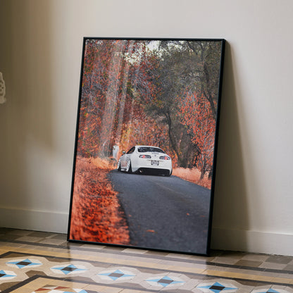 Toyota Supra MK4 driving on autumn road poster with vibrant fall foliage wall art.