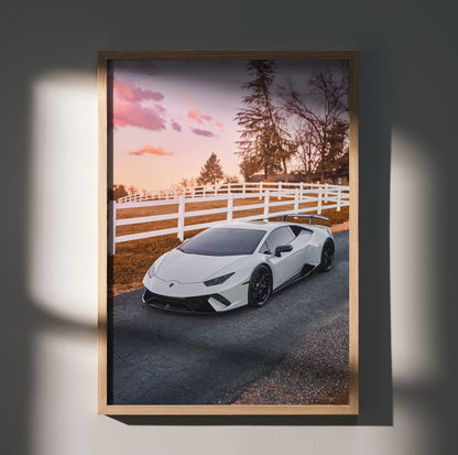 White Lamborghini Huracan parked on road by white fence at sunset poster wall art.