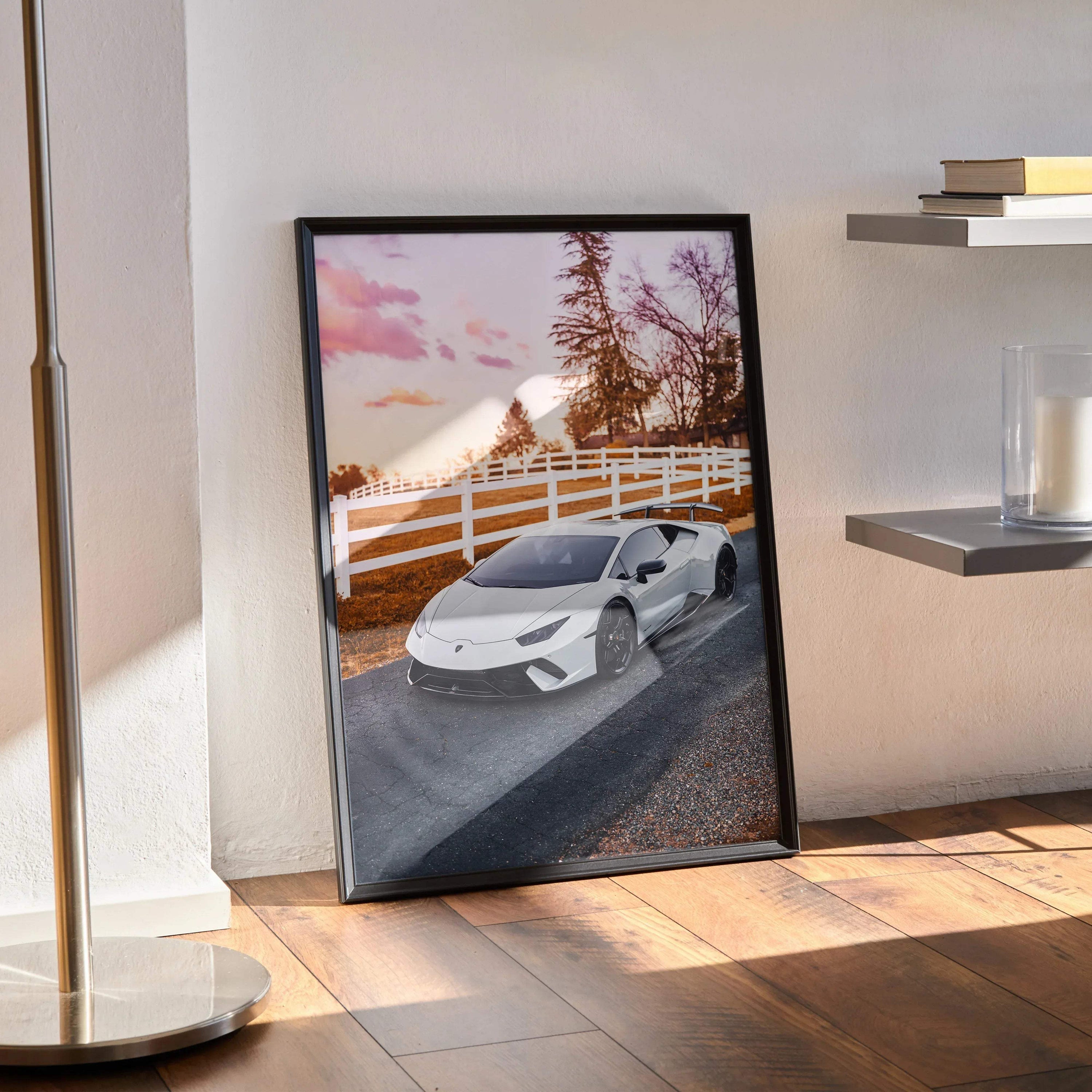 Lamborghini Huracan poster wall art with white car on road at sunset, framed and leaning on floor.