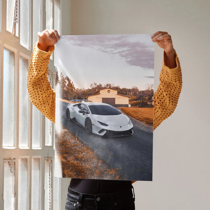Lamborghini Huracan poster showing white sports car on rural road with building backdrop, premium wall art.