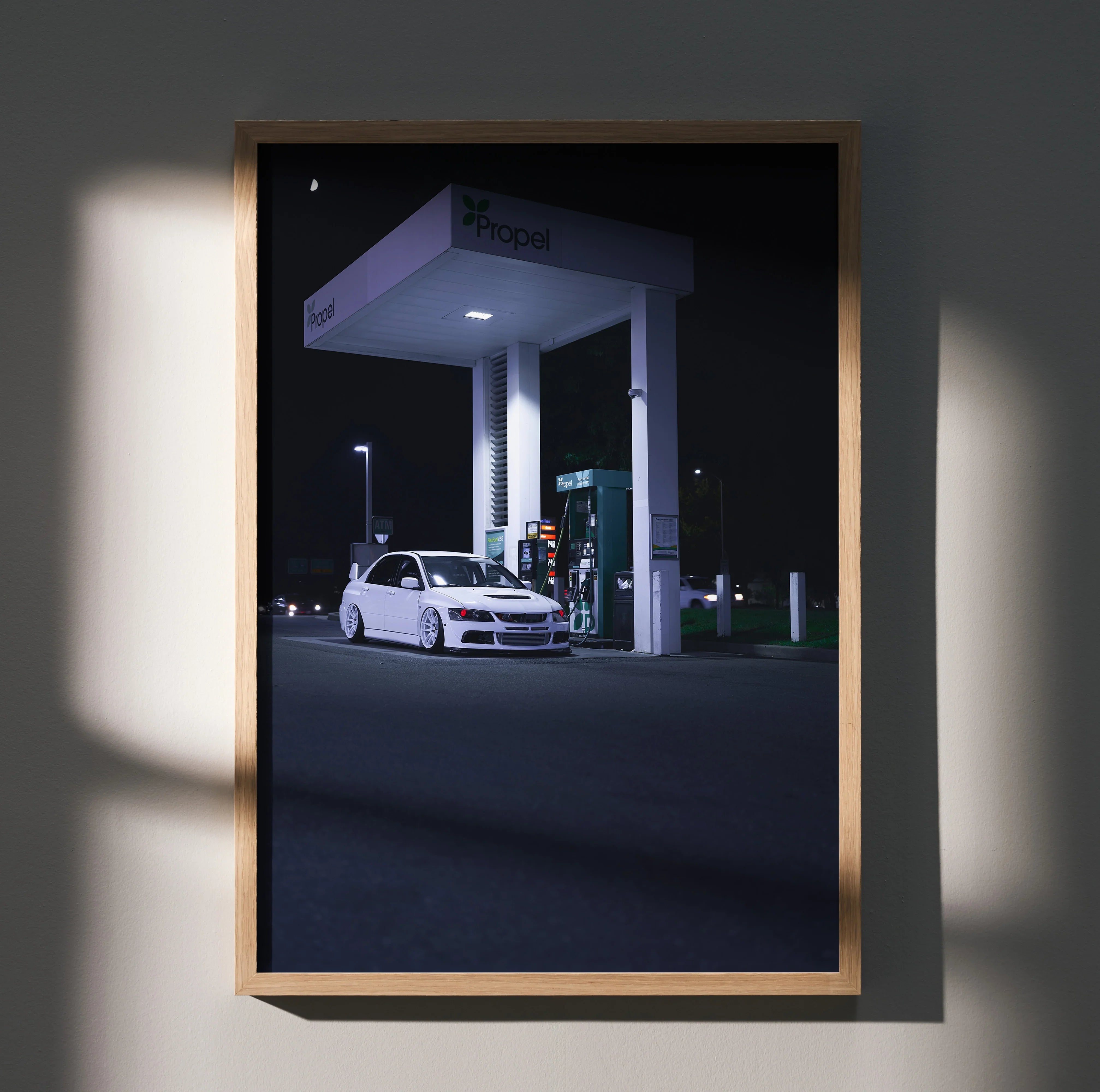 Mitsubishi Evo 8 white car at gas station at night poster wall art in wooden frame.
