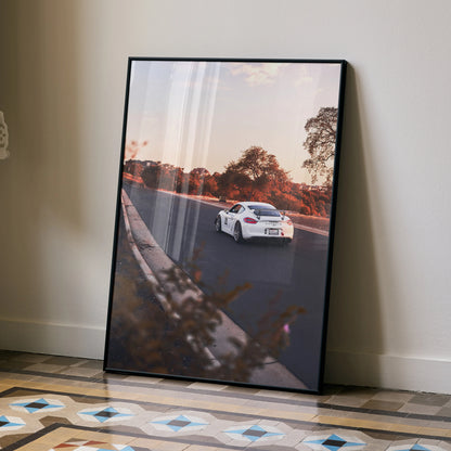 Porsche GT4 driving on road at sunset poster wall art with autumn trees and black frame.
