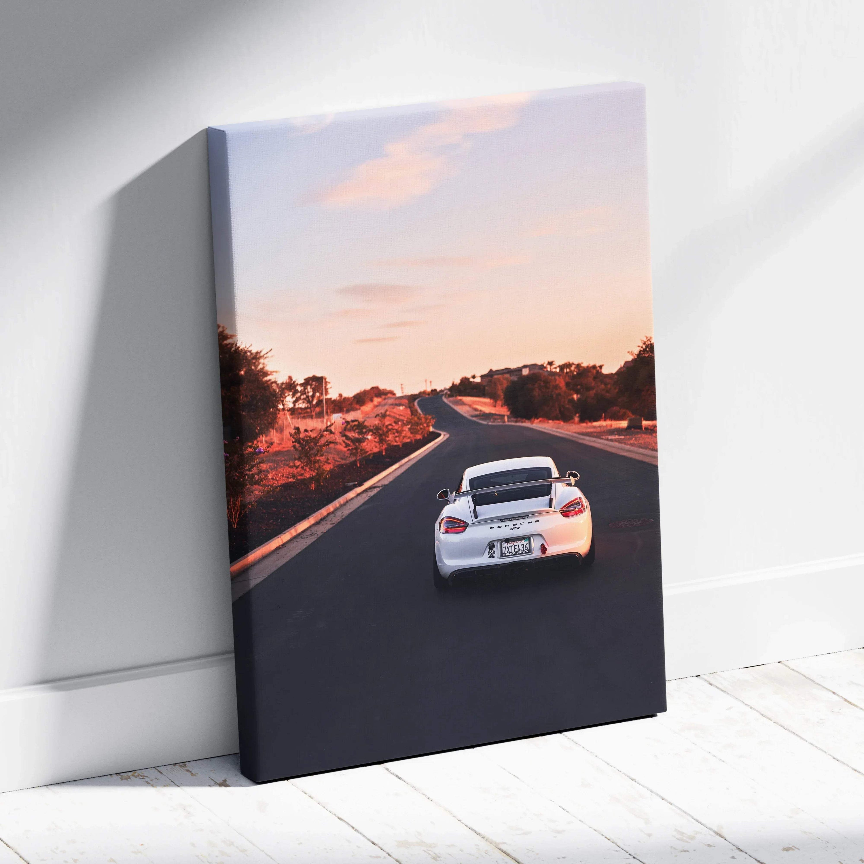 Porsche GT4 on open road at sunset canvas wall art in vertical format.