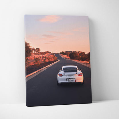 Vertical canvas wall art of white Porsche GT4 driving on sunset road.