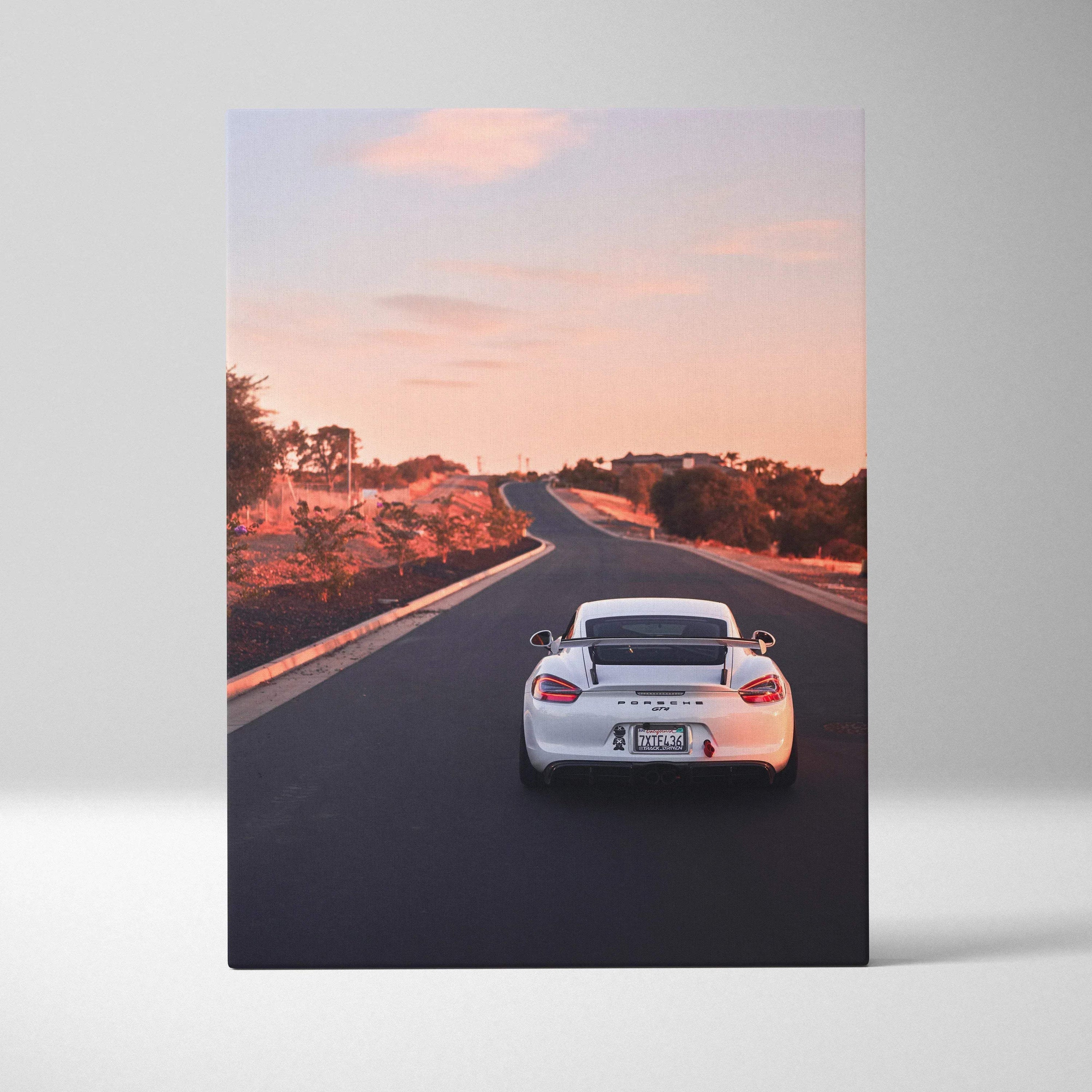 Porsche GT4 driving on sunset road vertical canvas wall art with warm sky and landscape.