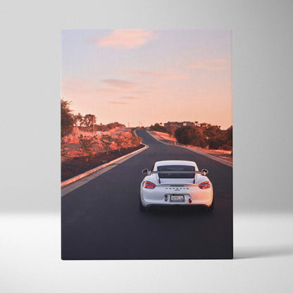 Porsche GT4 driving on sunset road vertical canvas wall art with warm sky and landscape.