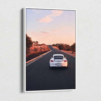 Vertical canvas wall art featuring a white Porsche GT4 driving on an open road at sunset.