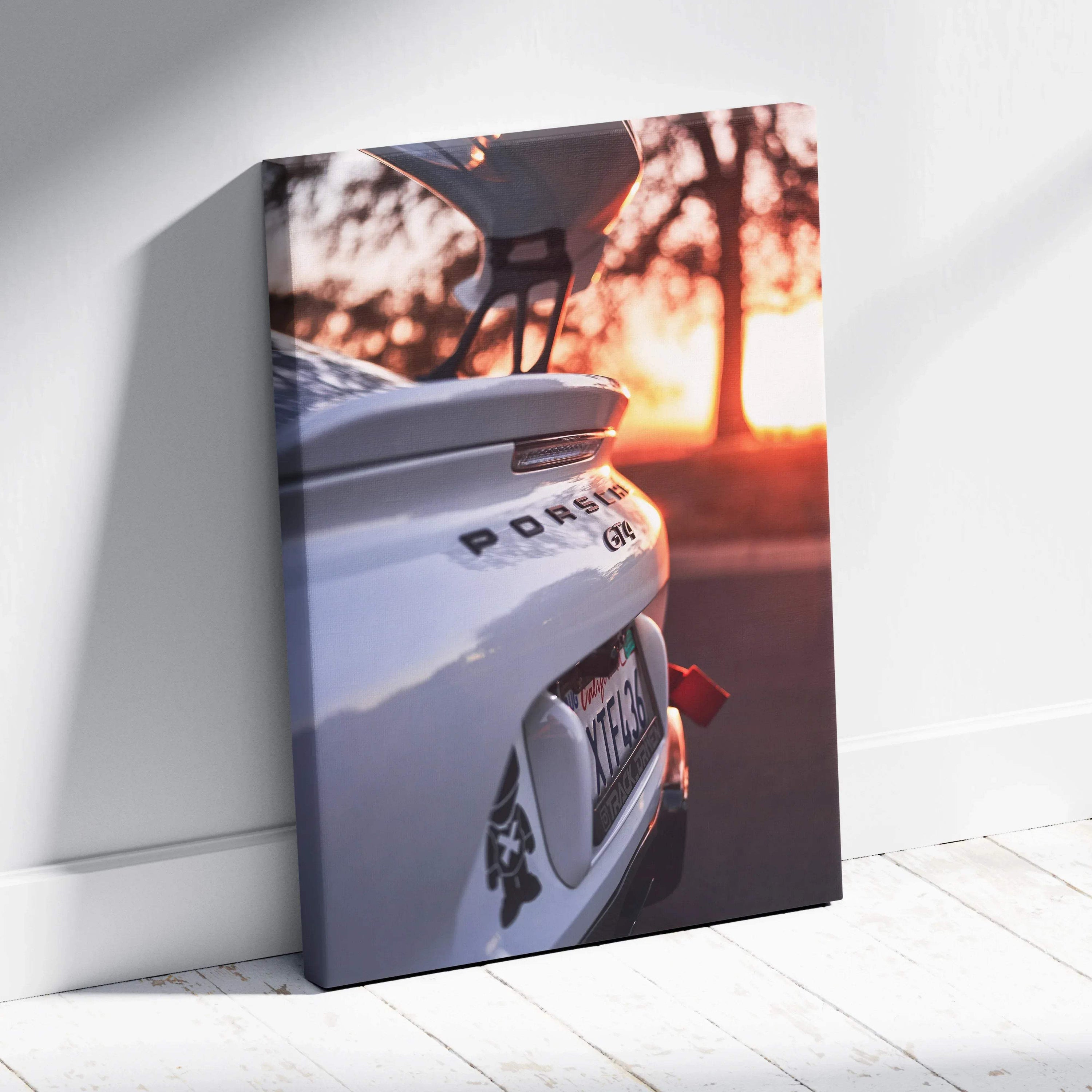 Vertical Porsche GT4 canvas wall art featuring rear car detail at sunset with warm orange sky background.