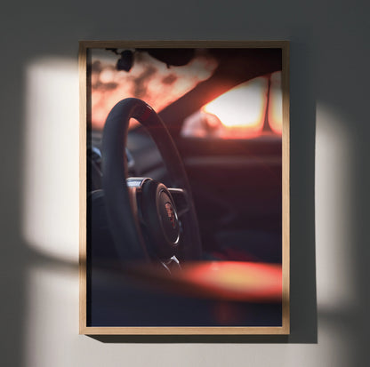 Porsche GT4 steering wheel close-up poster with warm sunset tones, automotive wall art.