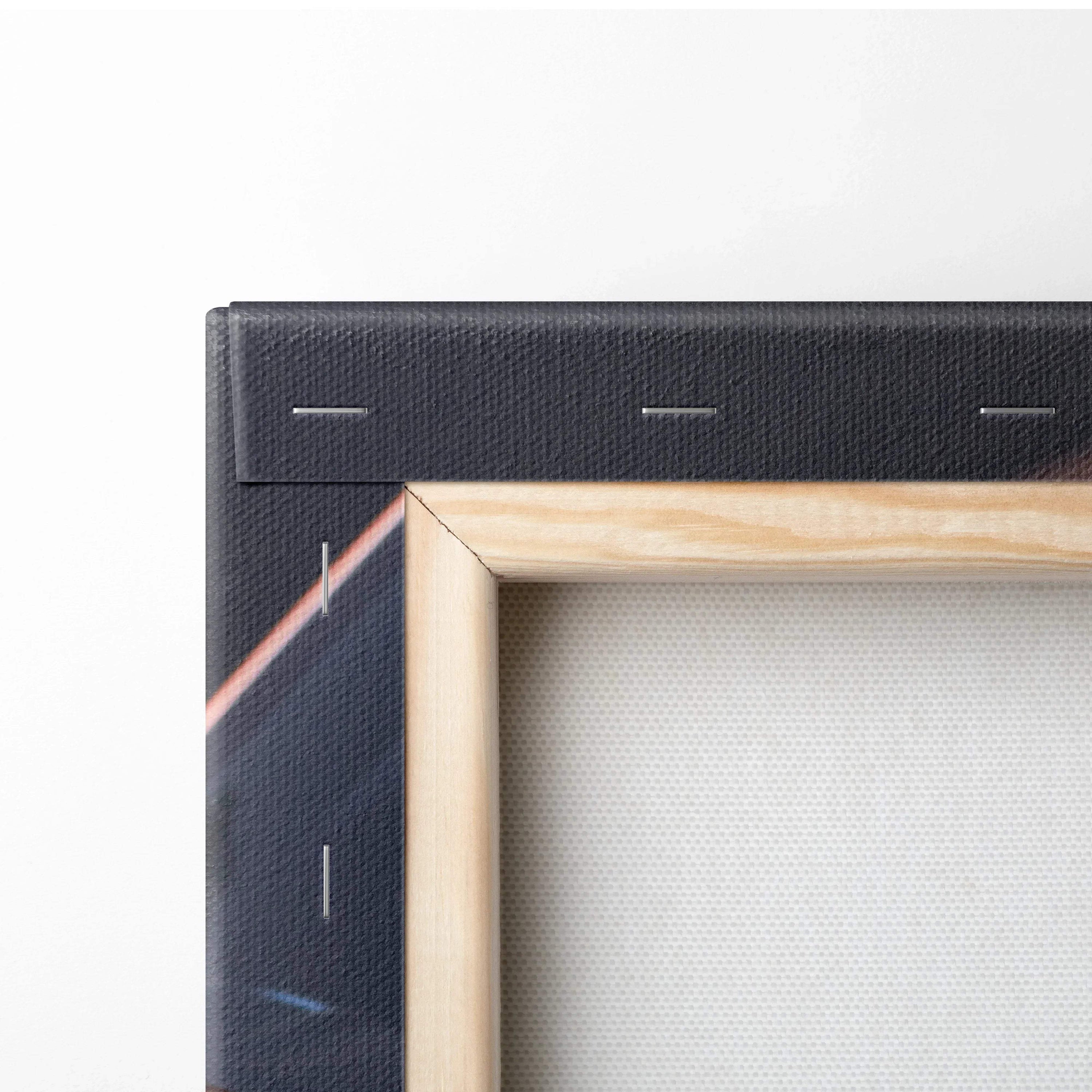 Close-up of wooden frame and corner stretch of black canvas wall art with visible staples and textured canvas material.