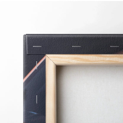Close-up of wooden frame and corner stretch of black canvas wall art with visible staples and textured canvas material.