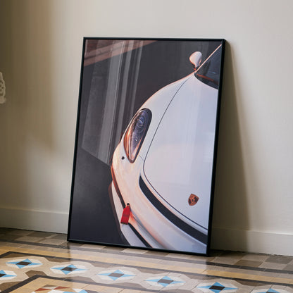 Porsche Cayman GT4 close-up poster leaning against wall with geometric floor tiles, wall art decor.