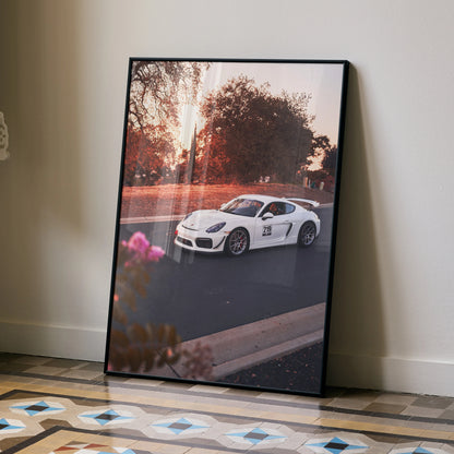 Porsche Cayman GT4 poster with sunset backdrop, luxury automotive wall art in a black frame.