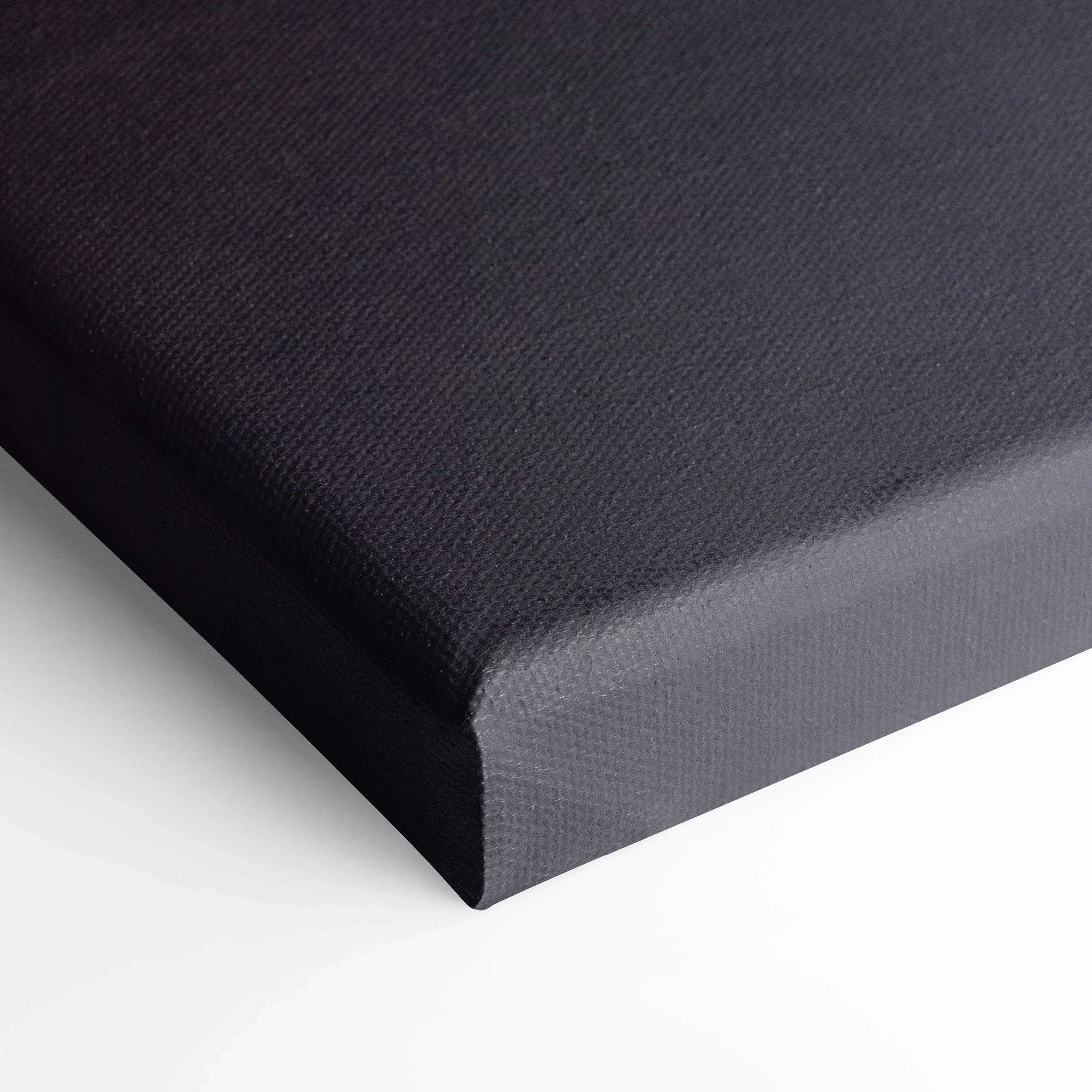 Close-up of black stretched canvas wall art corner with textured surface and neatly wrapped edges.