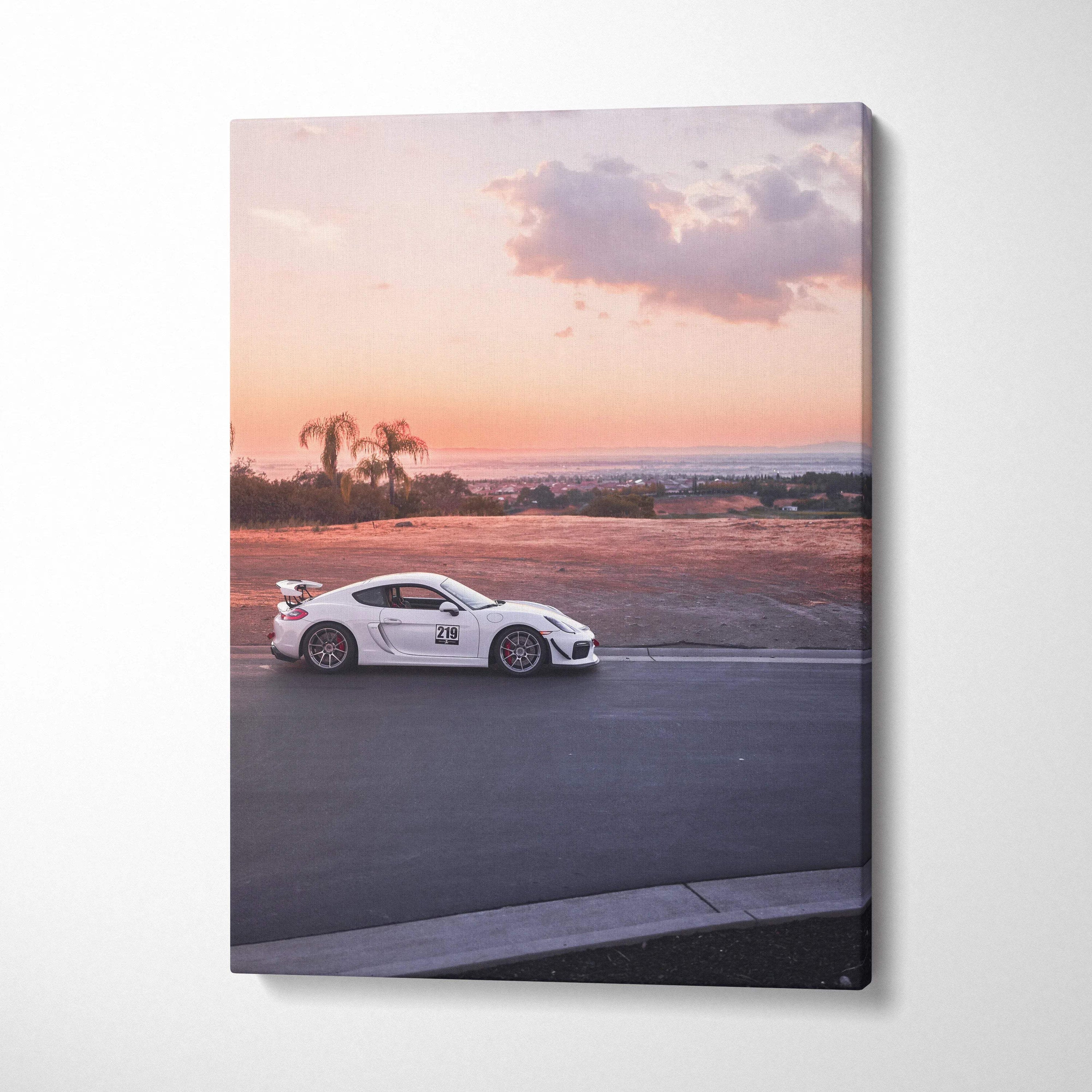 Vertical Porsche GT4 canvas wall art showing white race car on road at sunset.