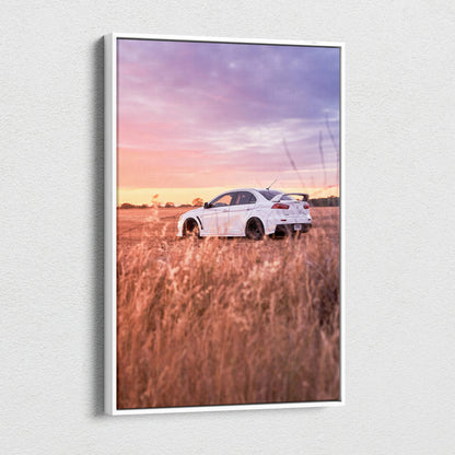 Vertical canvas wall art featuring a white Mitsubishi Evo 10 in a golden field under a pink and purple sunset sky.