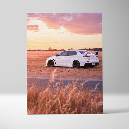 White Mitsubishi Evo 10 sports car on dirt road under pink sunset sky vertical canvas wall art.