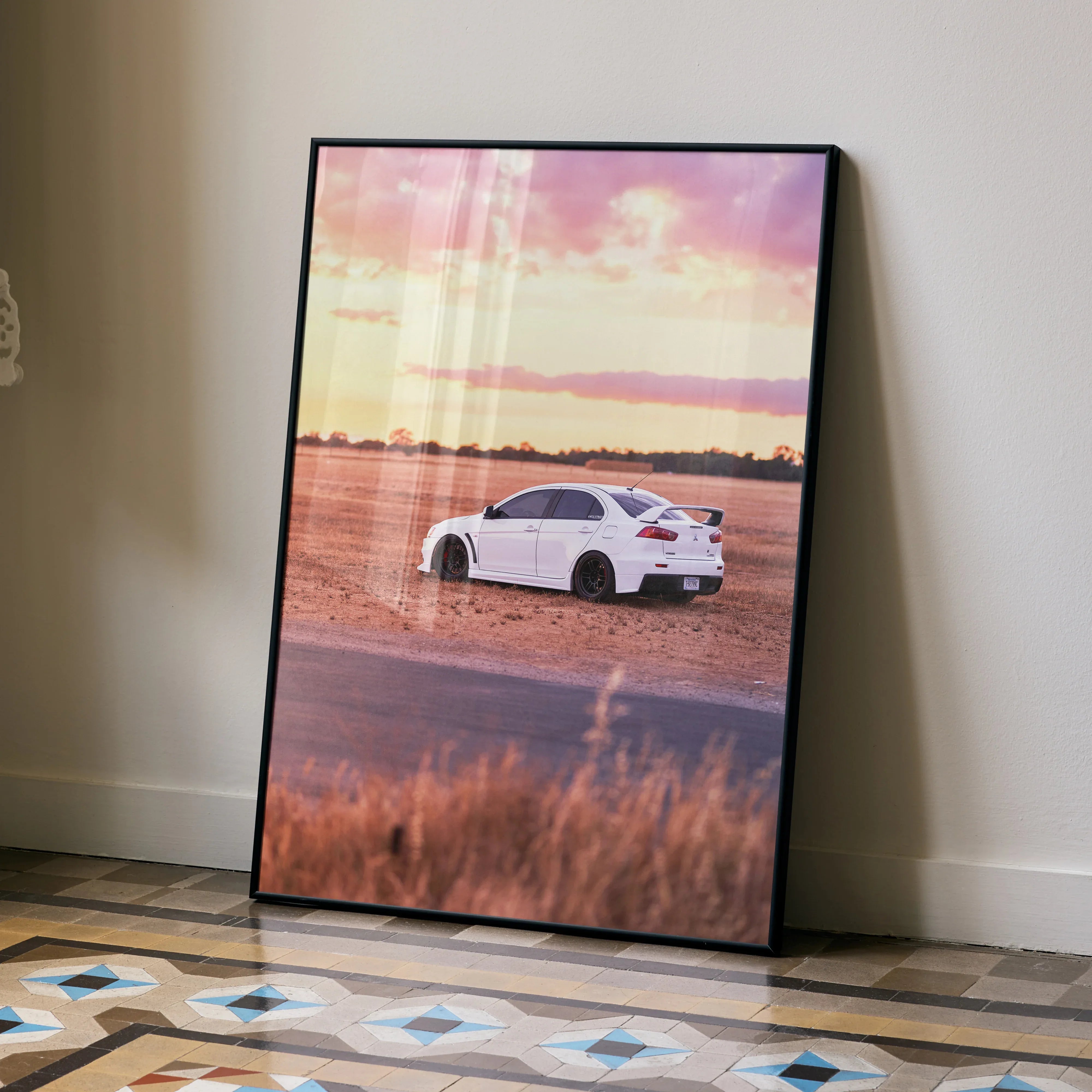 Mitsubishi Evo 10 poster featuring a white car on a dirt road at sunset, wall art with scenic background.
