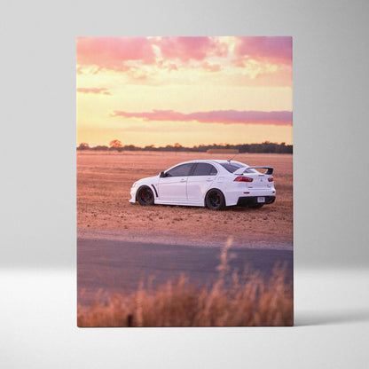 Vertical canvas wall art featuring a white Mitsubishi Evo 10 parked on a desert landscape at sunset.