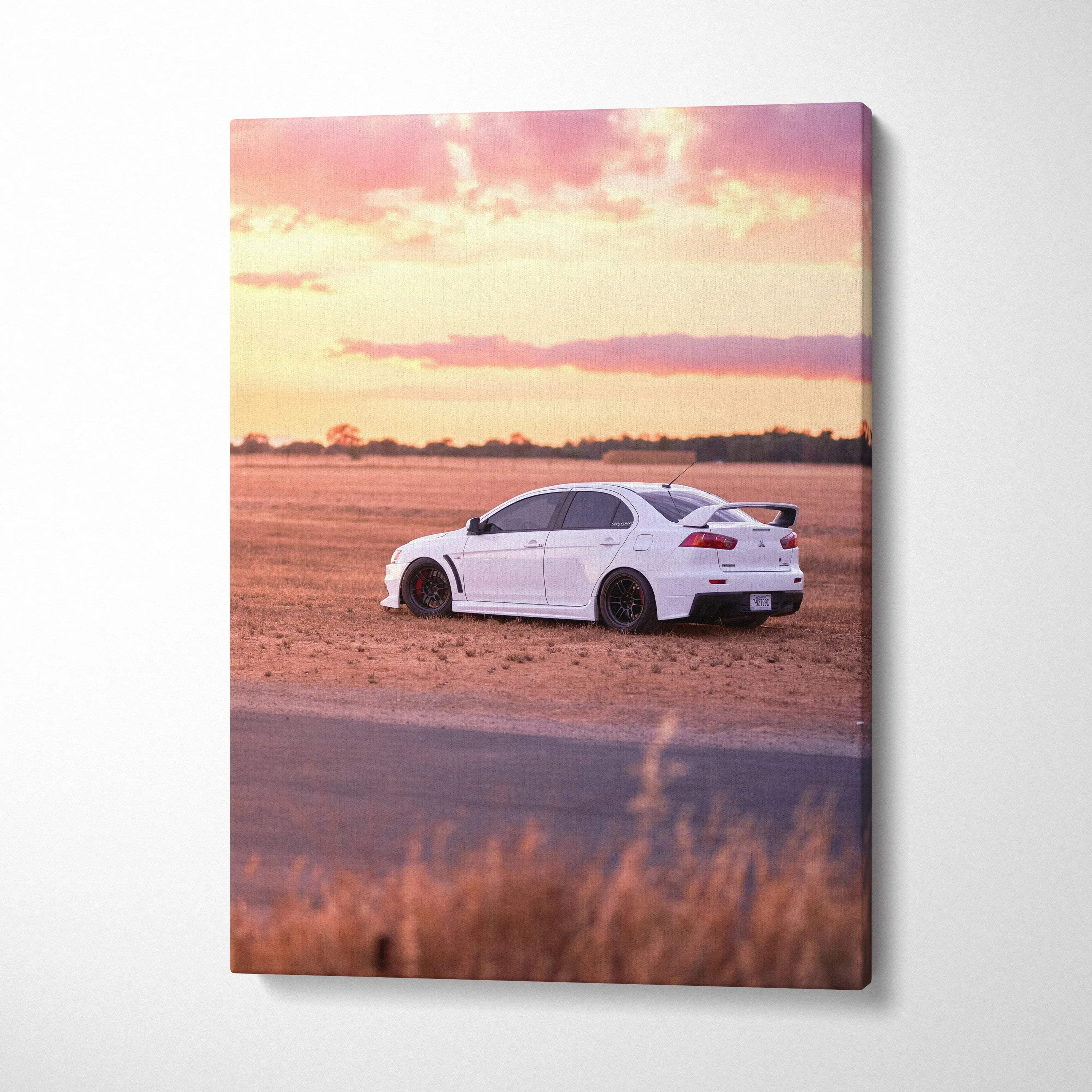 White Mitsubishi Evo 10 on dirt road at sunset vertical canvas wall art.