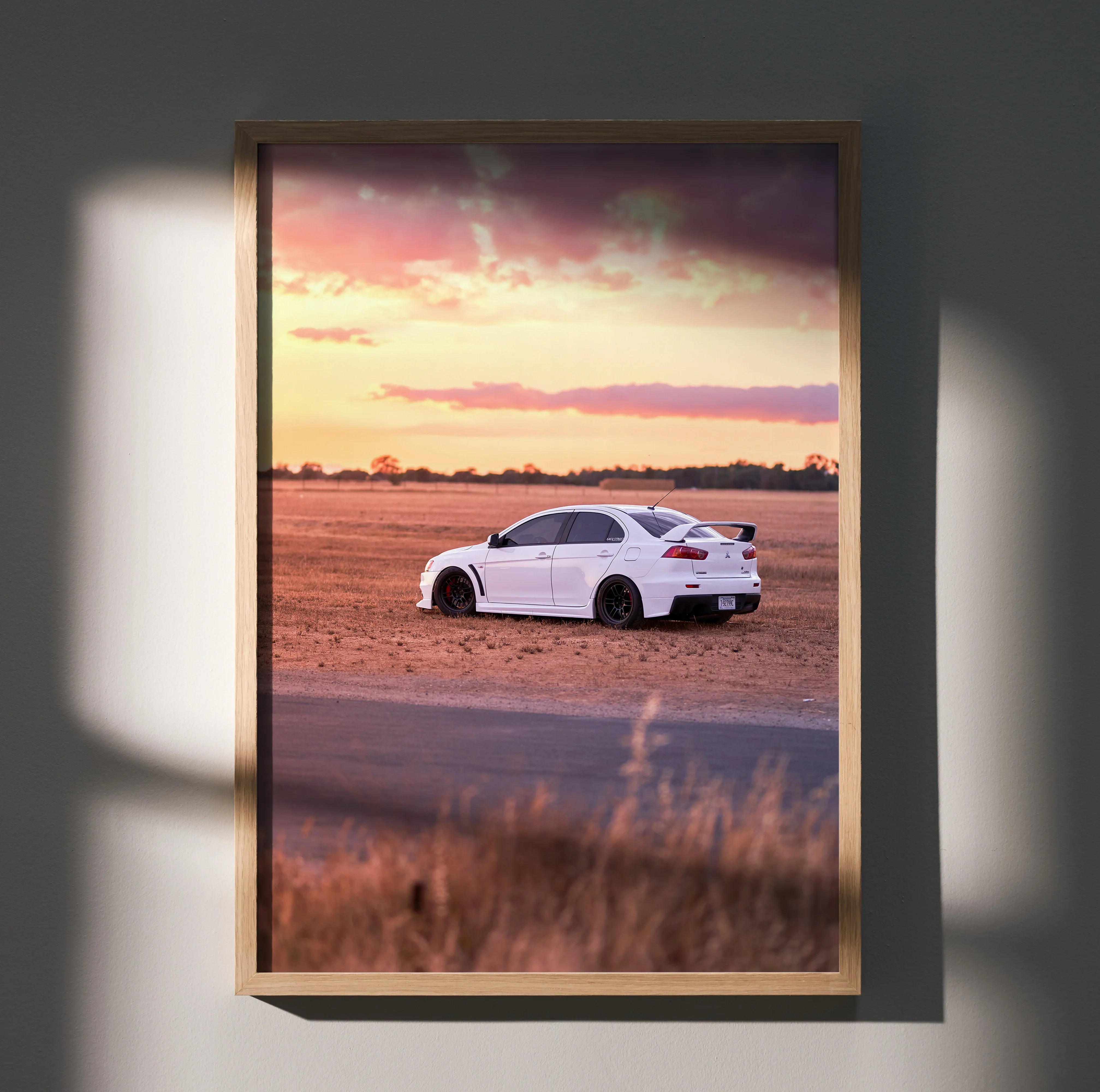 Mitsubishi Evo 10 on dirt road at sunset poster wall art in wooden frame.