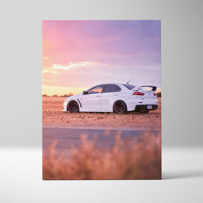 White Mitsubishi Evo 10 on sandy terrain at sunset vertical canvas wall art.