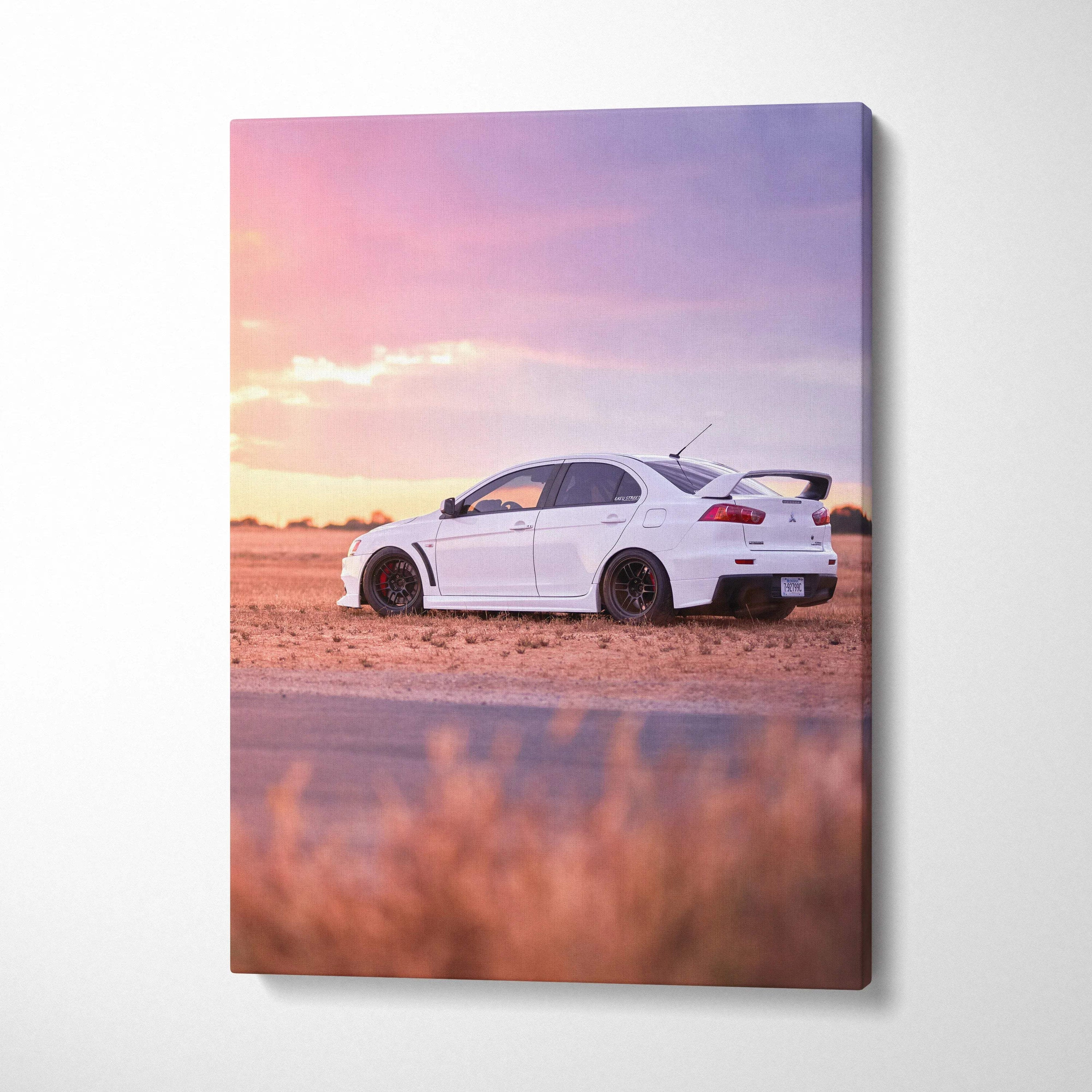 White Mitsubishi Evo 10 on desert road at sunset vertical canvas wall art.