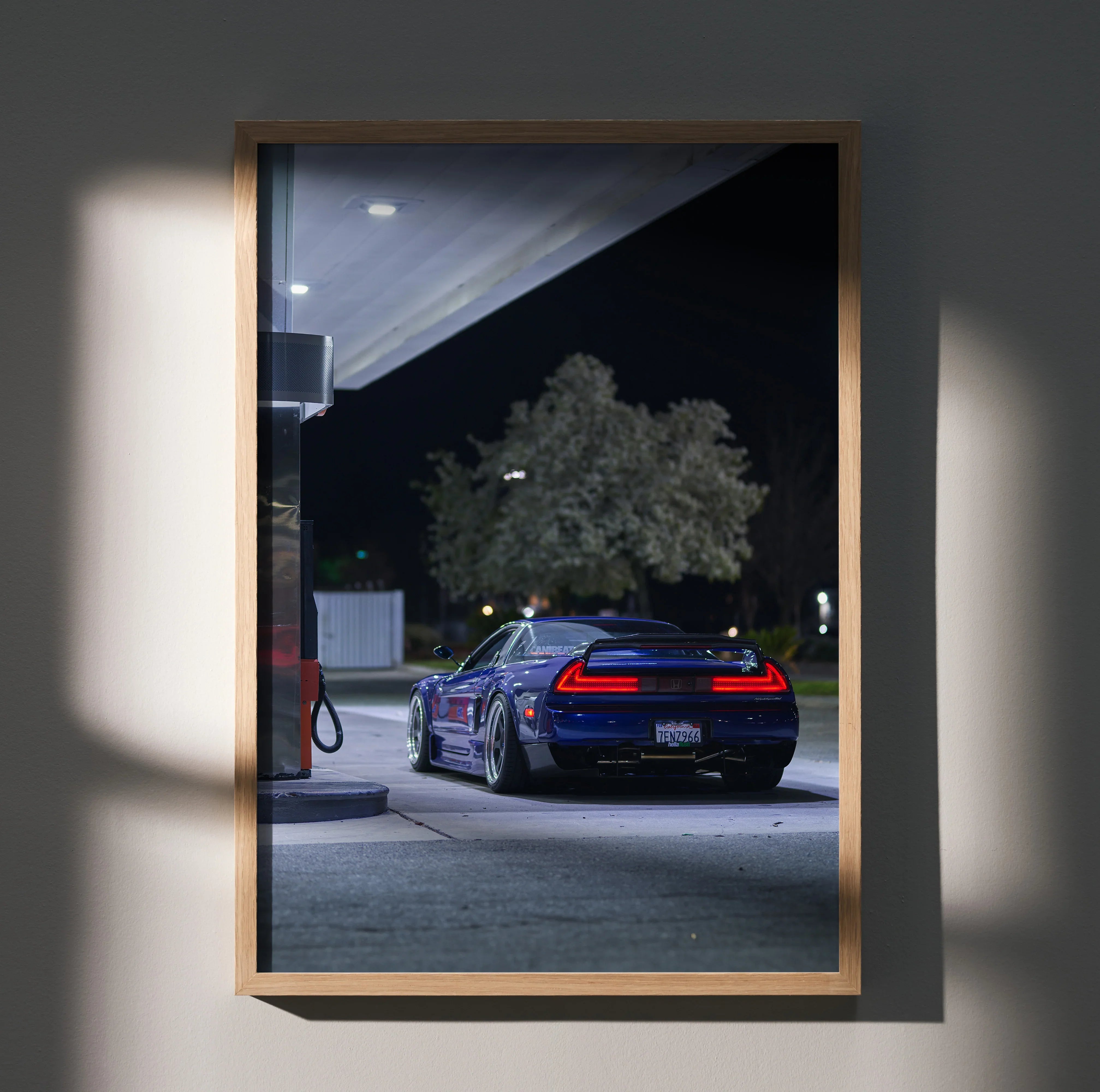 Acura NSX poster wall art showing rear view of blue sports car at night by gas station.