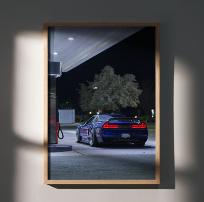 Acura NSX poster wall art showing rear view of blue sports car at night by gas station.