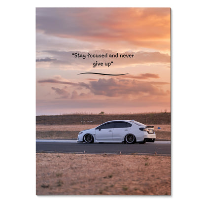 Motivational poster wall art featuring white Subaru WRX on a road at sunset with inspiring text.