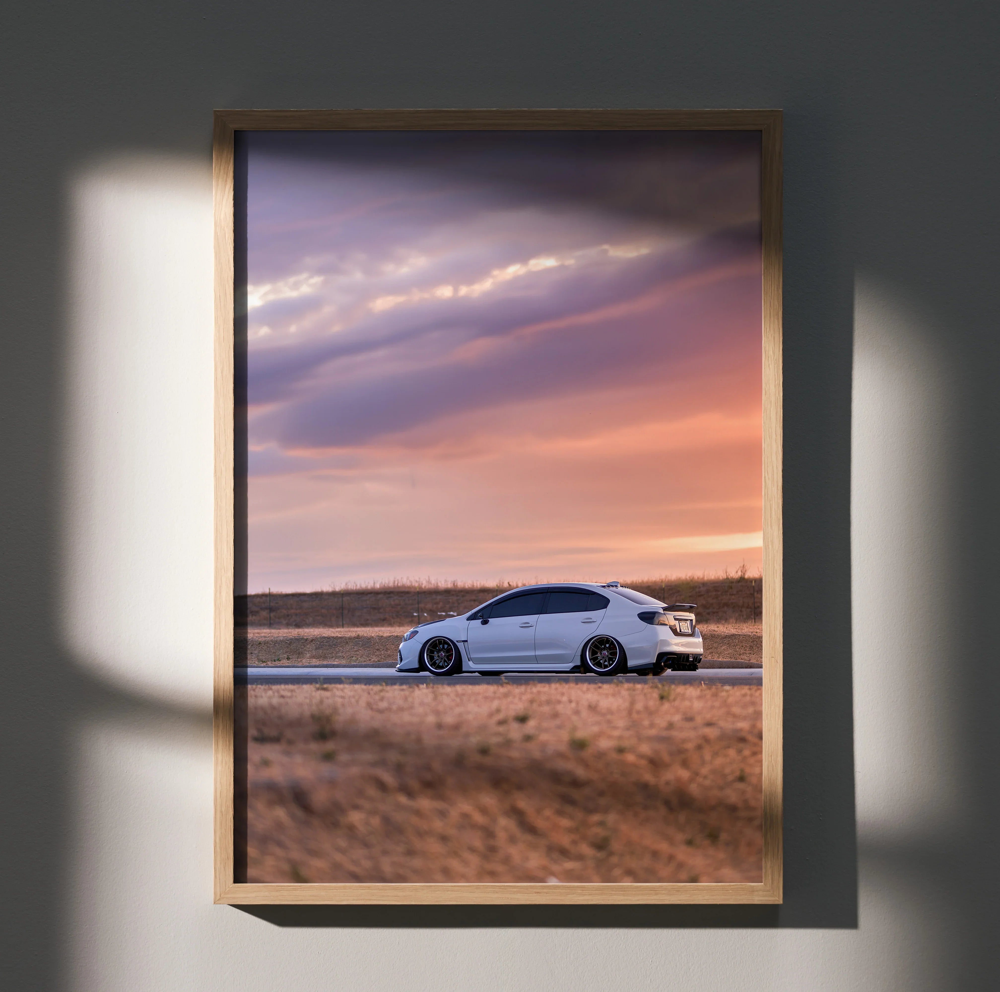 Subaru WRX driving on open road at sunset framed as premium wall art poster.