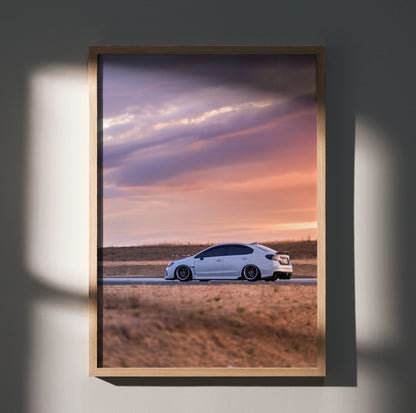 Subaru WRX driving on open road at sunset framed as premium wall art poster.