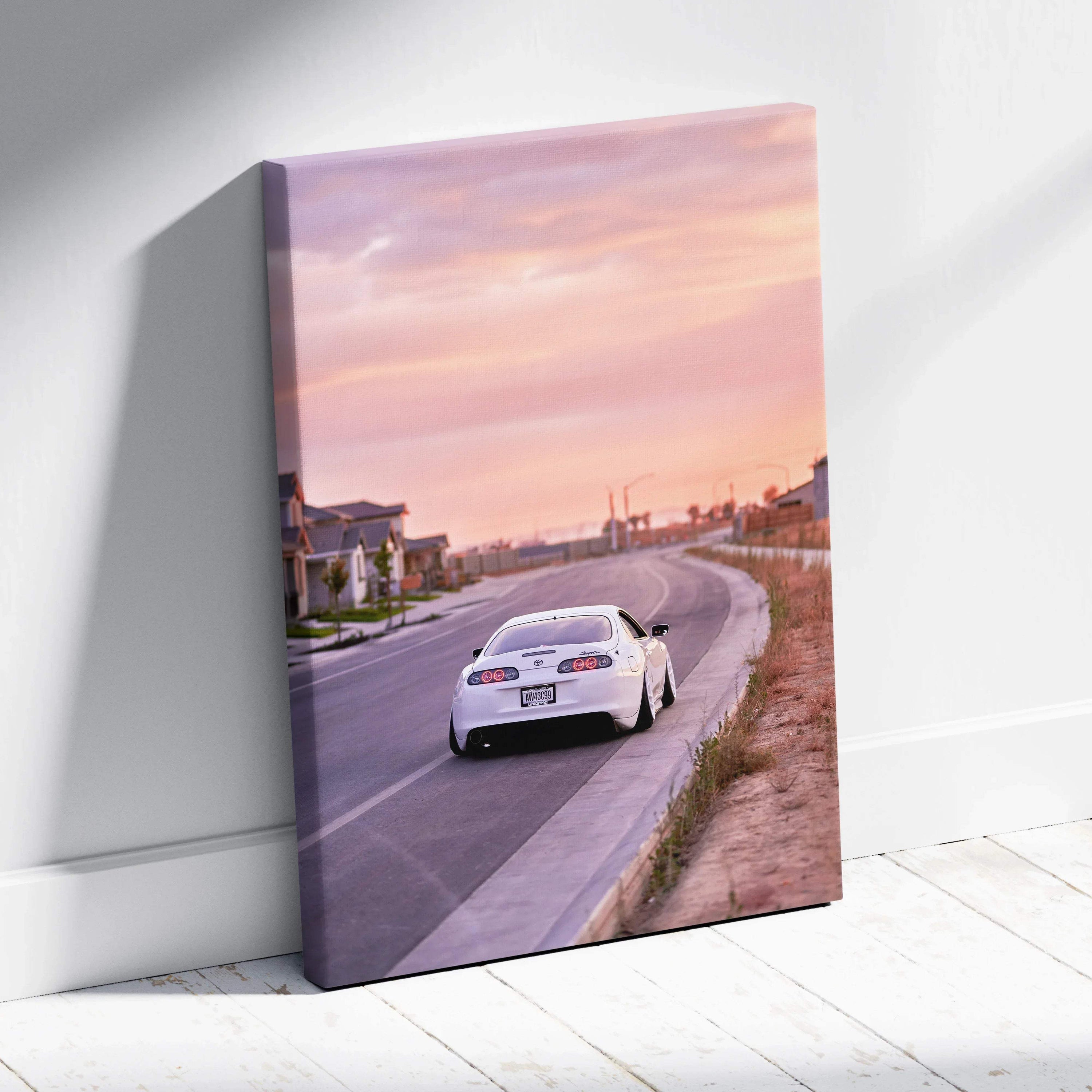 Toyota Supra MK4 driving on road at sunset canvas wall art with soft pink sky background.