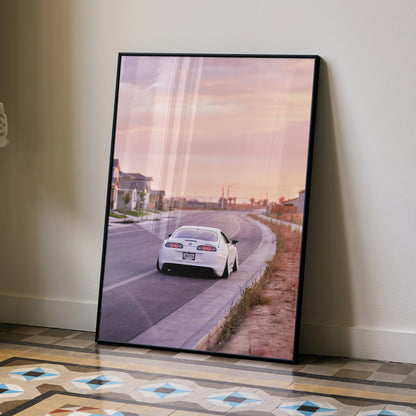 Supra MK4 driving on road at sunset poster wall art with soft purple and orange sky.