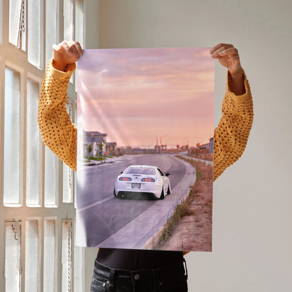 Toyota Supra MK4 driving at sunset on road poster wall art in soft pink and orange tones.